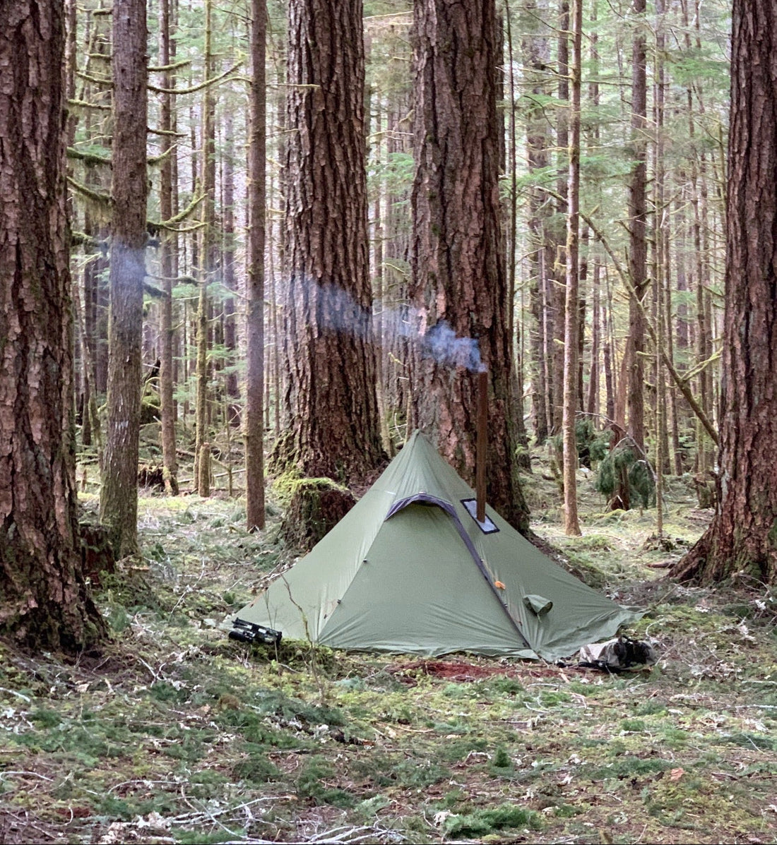 Backpacking campsite with wood stove hot tent in the forest