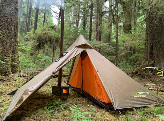 Backpacking campsite with tent wood stove in the forest