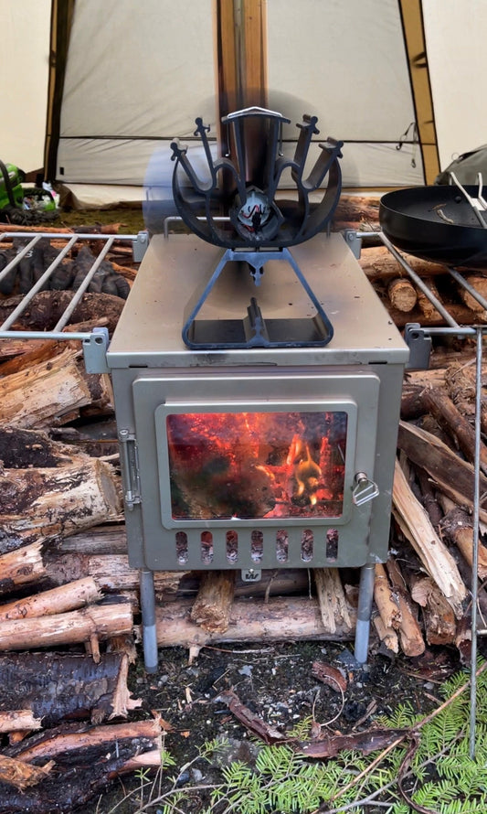 Beginner freestanding hot tent wood stove with firewood pile and thermal fan
