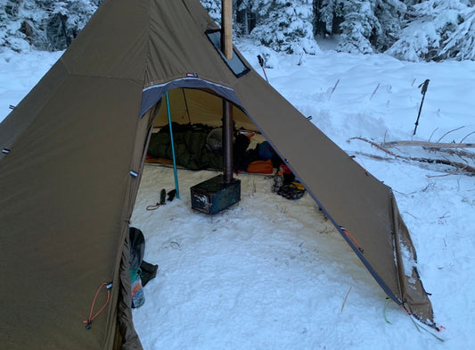 Winter camping on the snow with a tent wood stove