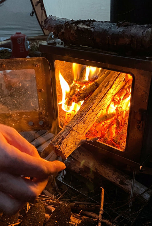 Thick coal bed inside tent wood stove while camping 