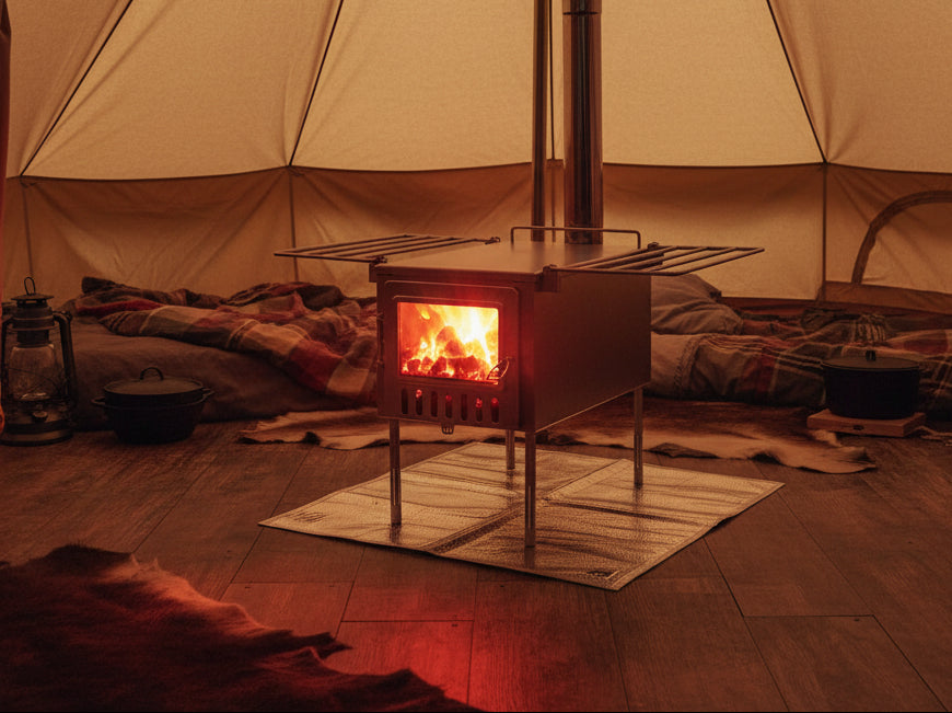 Hot coals in tent wood stove inside glamping shelter