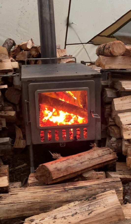 Tent wood stove and pile of firewood