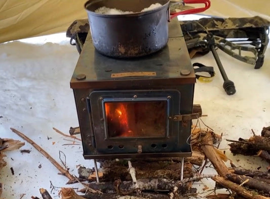 Titanium tent stove melting snow on the stovetop 