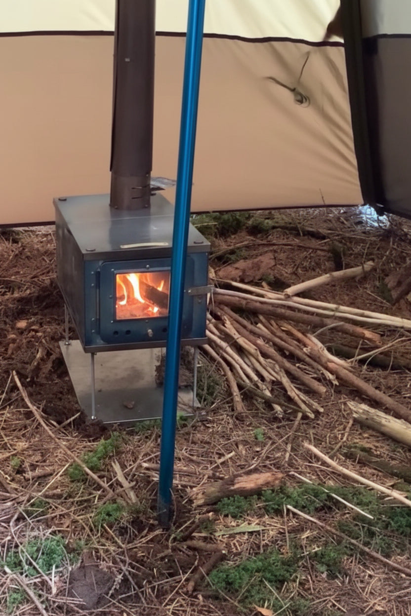 Titanium tent wood stove setup in campsite