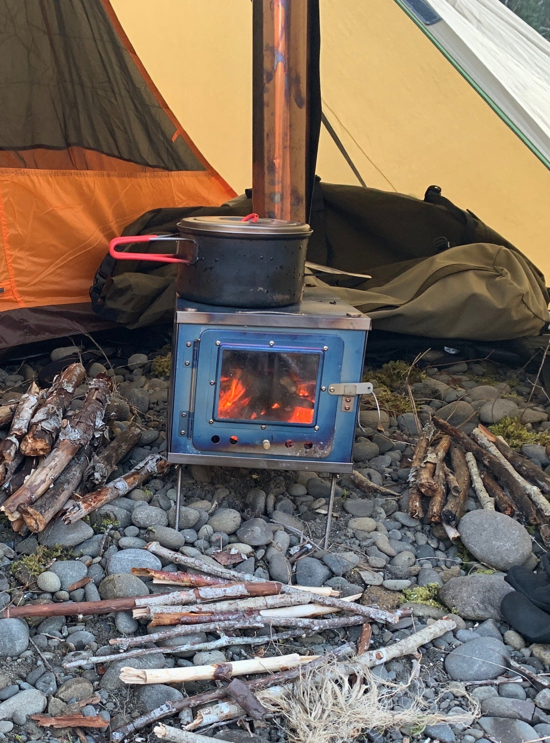 Titanium tent wood stove setup in camp