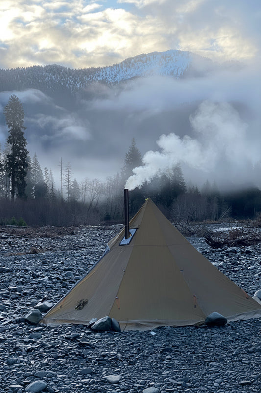 Ultralight backpacking elk hunting hot tent campsite with snowy mountain views