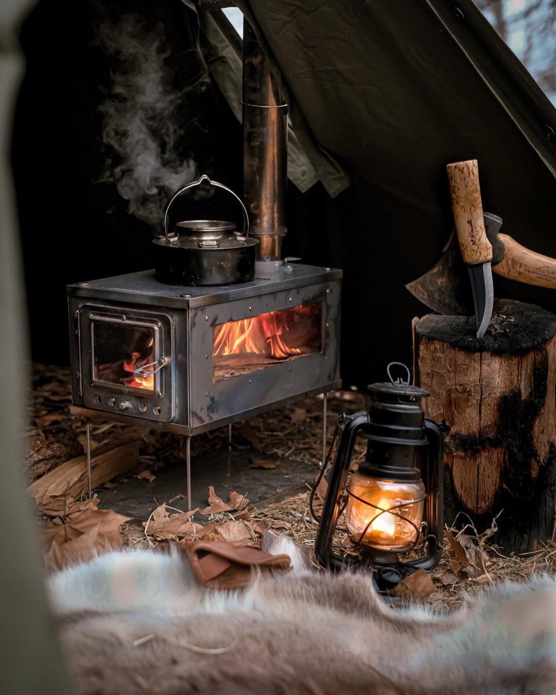 Premium titanium tent wood stove in bushcraft style campsite