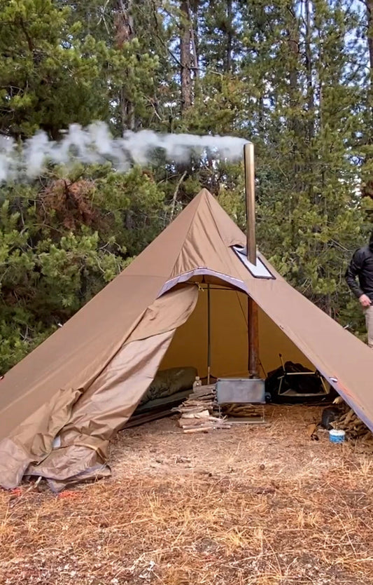 Windy backcountry campsite with tent wood stove