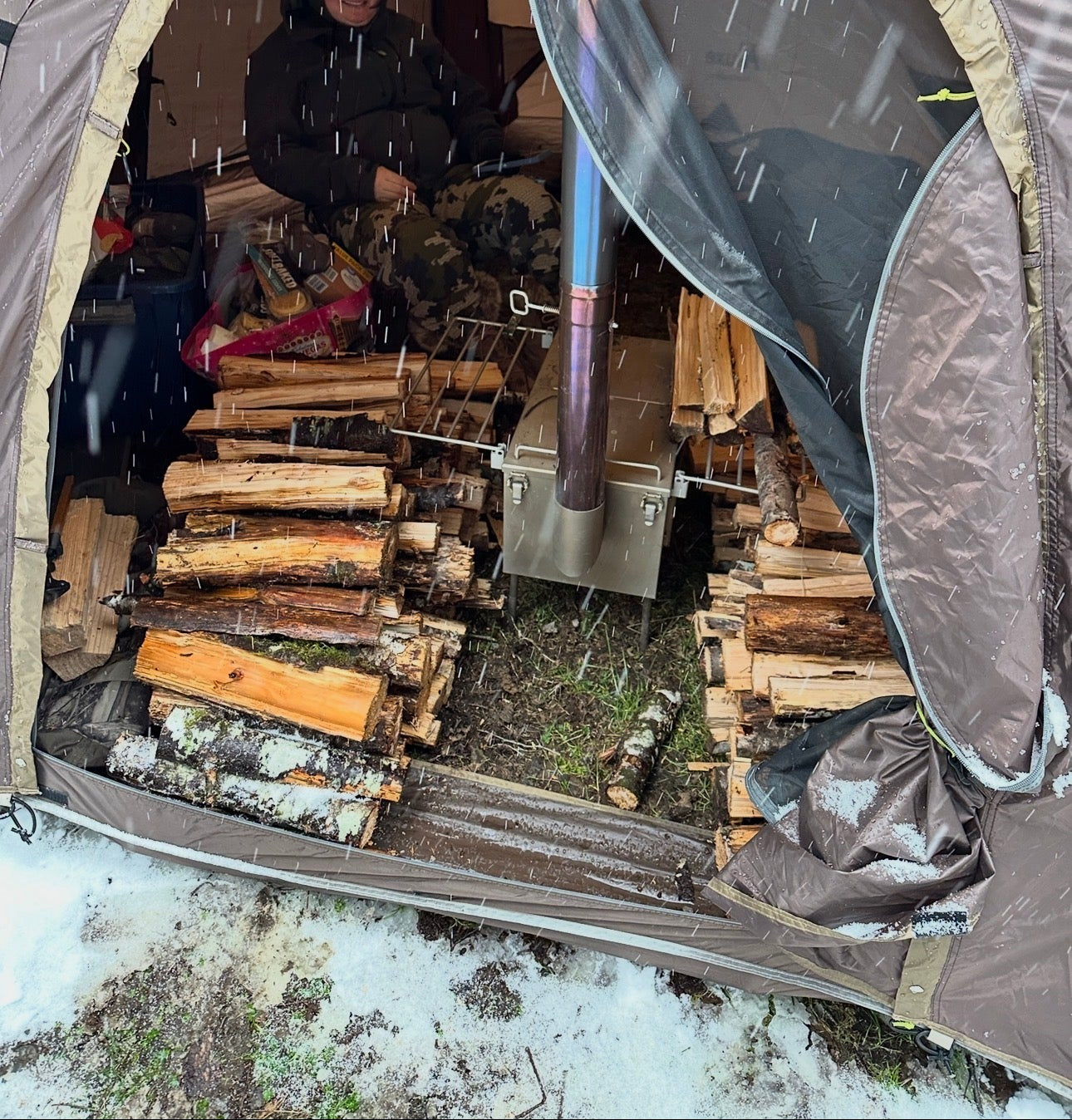 Wild Wild West Wood Stove tent camping with a stockpile of firewood while its snowing