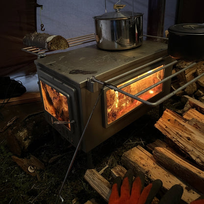 X-stove XL Hot Tent Wood Stove with pot on stovetop and stockpile of firewood with gloves